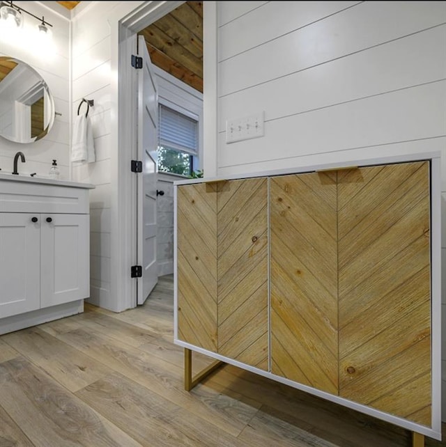 bathroom featuring vanity, wood walls, and wood-type flooring