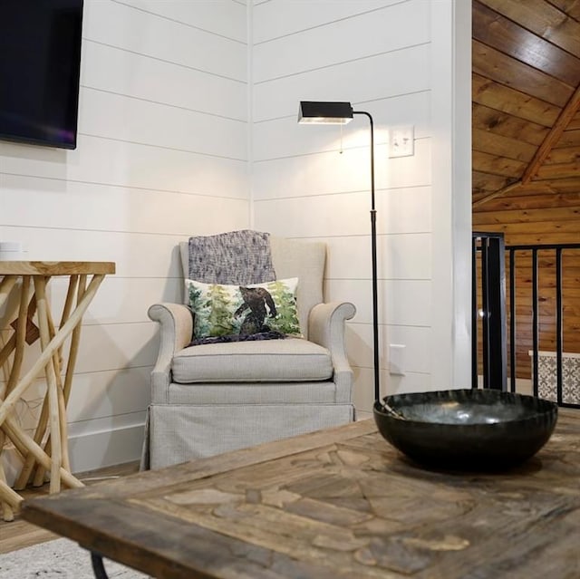 living area featuring hardwood / wood-style flooring, wood ceiling, lofted ceiling, and wood walls