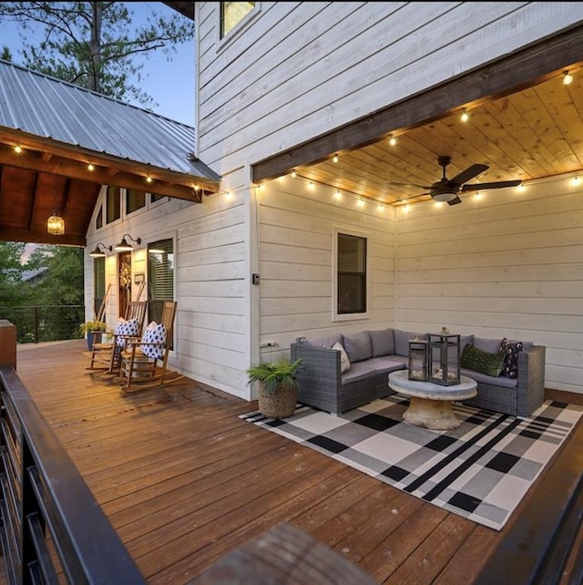 deck at dusk featuring an outdoor living space and ceiling fan