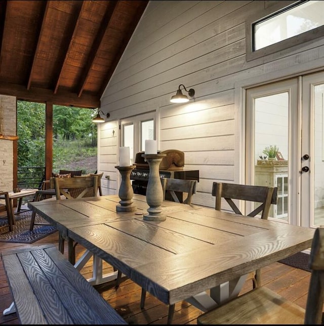 dining room featuring beamed ceiling, high vaulted ceiling, wooden walls, wood ceiling, and hardwood / wood-style flooring