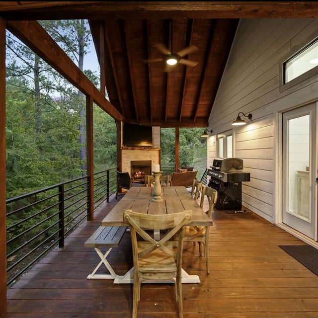 wooden terrace with a grill, ceiling fan, and a fireplace