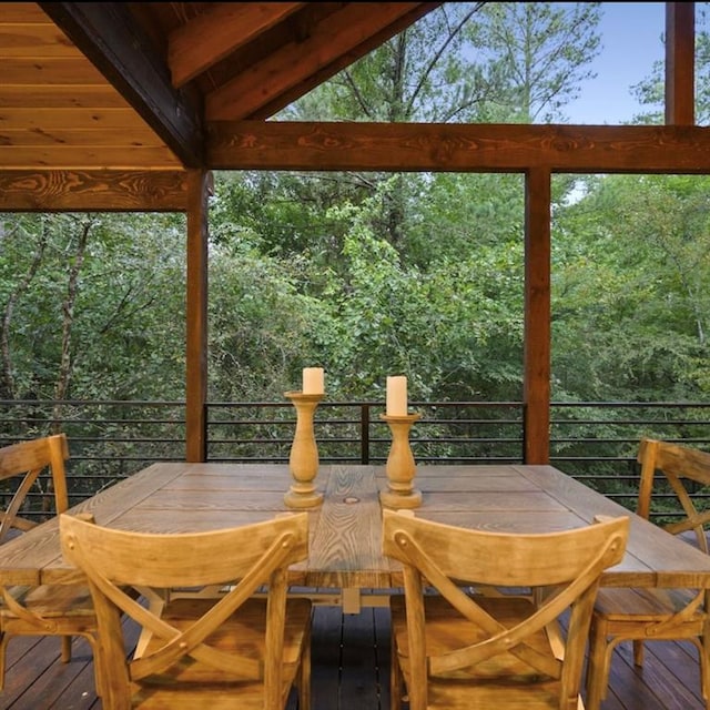 sunroom / solarium featuring vaulted ceiling with beams and plenty of natural light