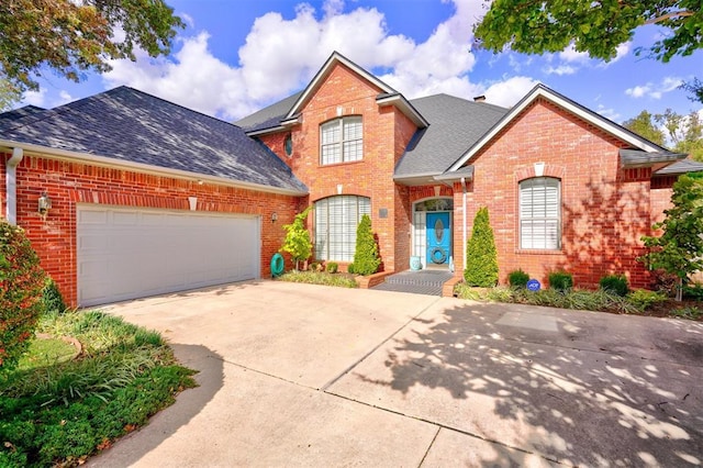 traditional-style house featuring concrete driveway, a garage, brick siding, and roof with shingles