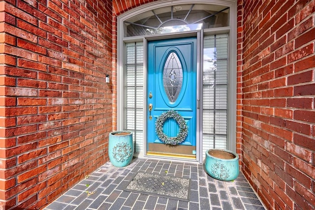 doorway to property featuring brick siding