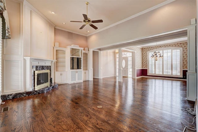 unfurnished living room featuring visible vents, ceiling fan with notable chandelier, dark wood finished floors, a fireplace, and crown molding