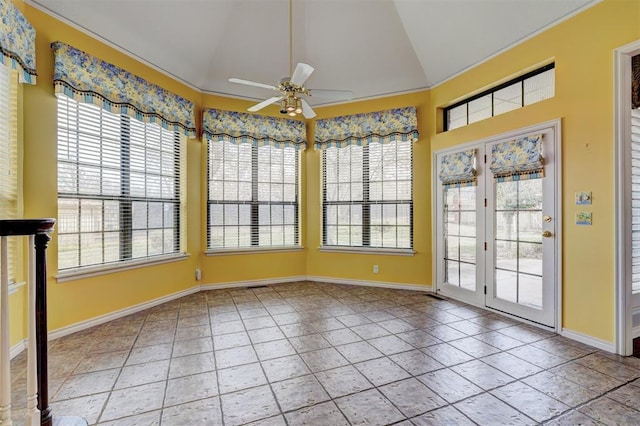 unfurnished sunroom with lofted ceiling, a ceiling fan, and a wealth of natural light