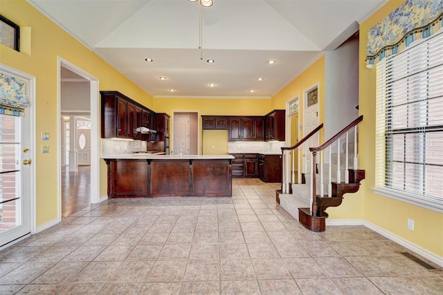 kitchen featuring visible vents, a peninsula, light countertops, crown molding, and tasteful backsplash