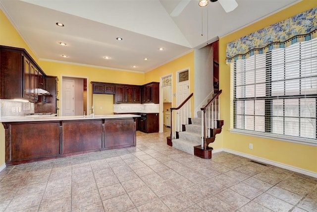 kitchen featuring a peninsula, light countertops, and ornamental molding