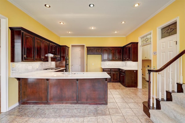 kitchen featuring a peninsula, light tile patterned flooring, a sink, light countertops, and backsplash