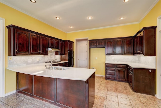 kitchen with a peninsula, a sink, light countertops, under cabinet range hood, and dobule oven black