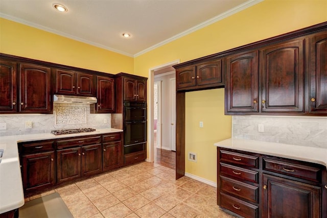 kitchen with ornamental molding, dobule oven black, under cabinet range hood, stainless steel gas stovetop, and light countertops