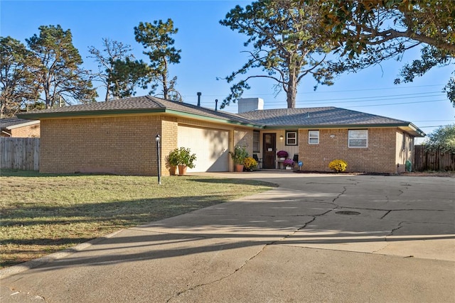 ranch-style house with a garage and a front lawn