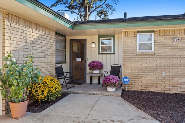 view of exterior entry with a patio