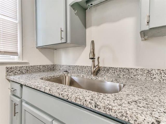 details featuring light stone counters and sink