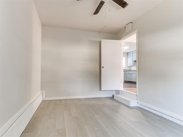 empty room with ceiling fan and light hardwood / wood-style floors