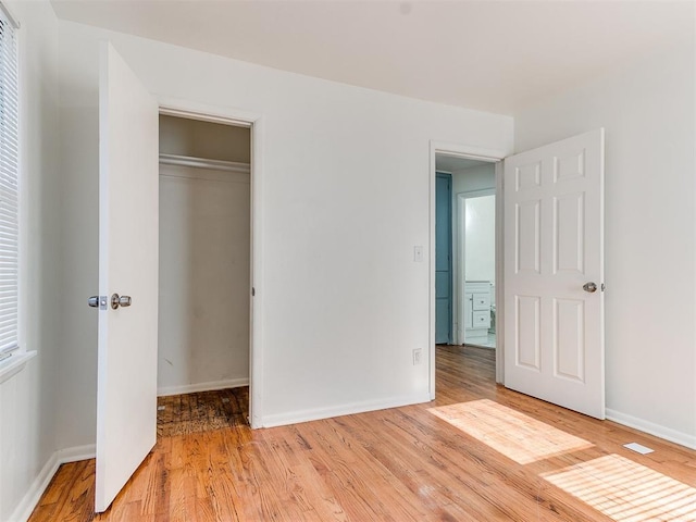 unfurnished bedroom with light hardwood / wood-style floors and a closet