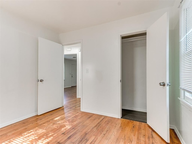 unfurnished bedroom with a closet and light wood-type flooring