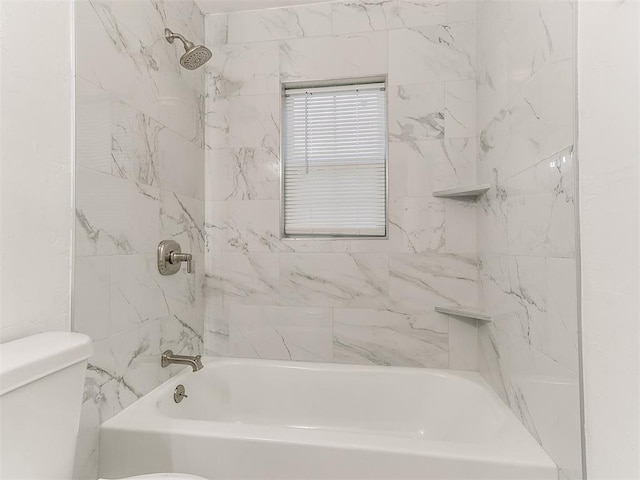 bathroom featuring tiled shower / bath and toilet