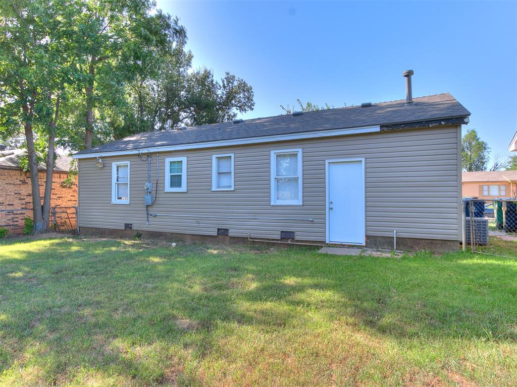 rear view of property featuring a lawn