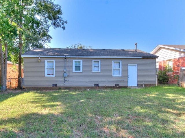 rear view of house featuring a yard