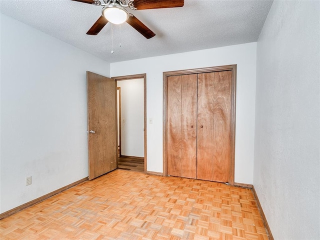 unfurnished bedroom featuring ceiling fan, light parquet floors, and a textured ceiling