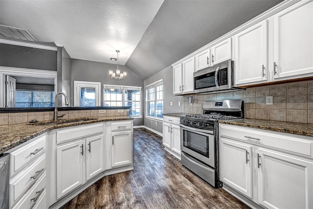 kitchen featuring white cabinets, stainless steel appliances, and vaulted ceiling