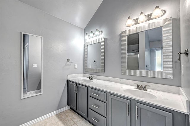 bathroom with tile patterned flooring, vanity, and lofted ceiling