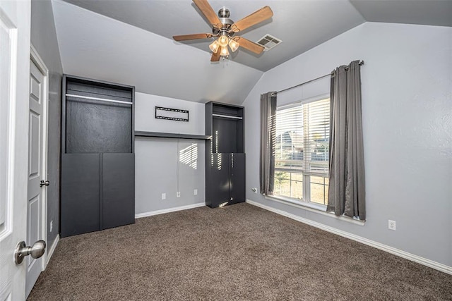 unfurnished bedroom with dark colored carpet, ceiling fan, and lofted ceiling