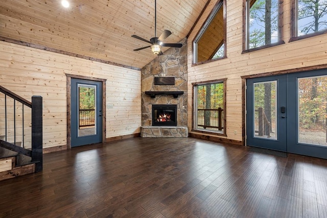 unfurnished living room with ceiling fan, wooden ceiling, high vaulted ceiling, dark hardwood / wood-style floors, and wooden walls