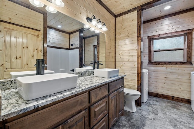 bathroom with vanity, toilet, and wooden walls