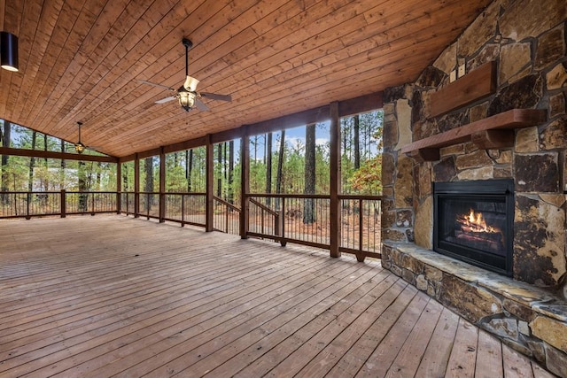 wooden deck featuring an outdoor stone fireplace and ceiling fan