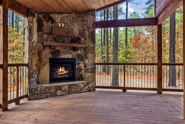 wooden terrace with an outdoor stone fireplace