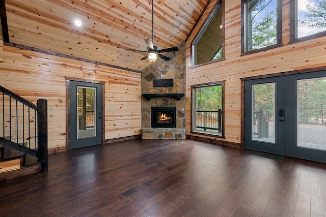 unfurnished living room with wood walls, high vaulted ceiling, wooden ceiling, and dark hardwood / wood-style floors