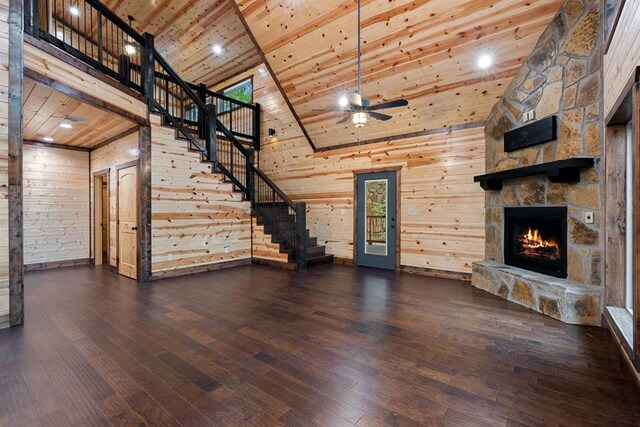 unfurnished living room featuring wooden walls, wood ceiling, dark wood-type flooring, and high vaulted ceiling