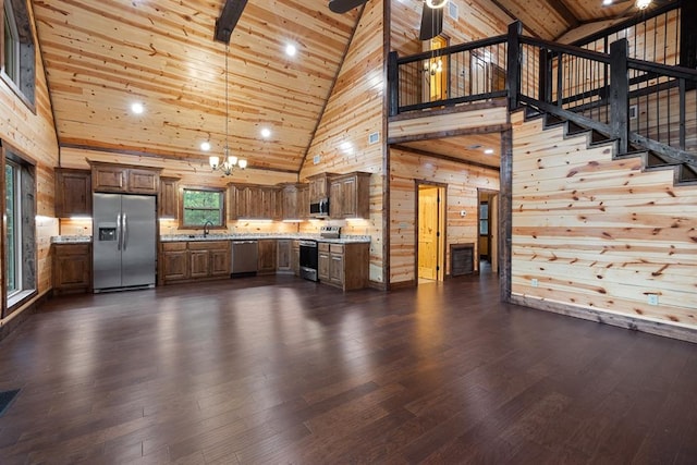 unfurnished living room featuring wooden walls, sink, high vaulted ceiling, and dark hardwood / wood-style floors