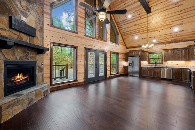 unfurnished living room with a fireplace, plenty of natural light, high vaulted ceiling, and dark hardwood / wood-style floors