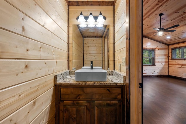 bathroom with wood ceiling, vanity, vaulted ceiling, hardwood / wood-style flooring, and wood walls