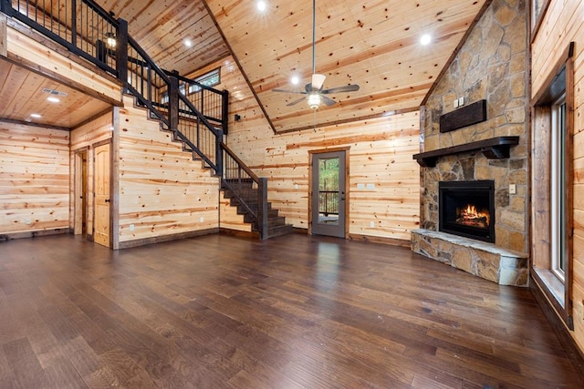 unfurnished living room featuring high vaulted ceiling, a stone fireplace, ceiling fan, dark hardwood / wood-style flooring, and wood ceiling