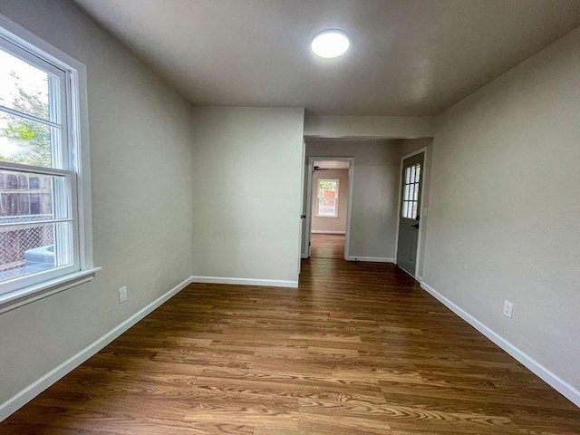 unfurnished room with dark hardwood / wood-style floors and a wealth of natural light