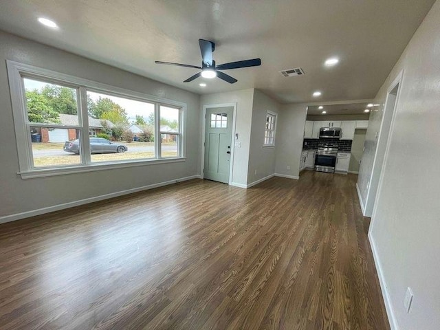 unfurnished living room featuring ceiling fan and dark wood-type flooring