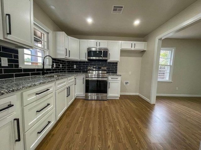 kitchen featuring a wealth of natural light, white cabinetry, and appliances with stainless steel finishes