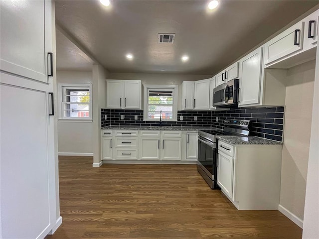 kitchen featuring white cabinetry, sink, stainless steel appliances, dark hardwood / wood-style flooring, and dark stone counters