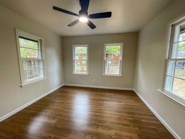 empty room featuring dark hardwood / wood-style floors, a healthy amount of sunlight, and ceiling fan