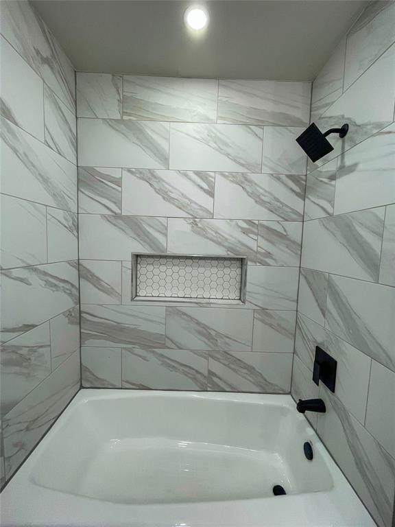 bathroom featuring tiled shower / bath