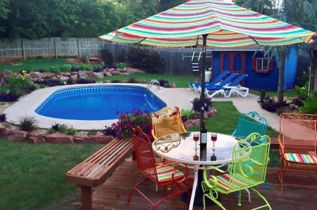 view of swimming pool with a wooden deck and a yard