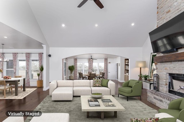 living room with a fireplace, ceiling fan, hardwood / wood-style floors, and high vaulted ceiling