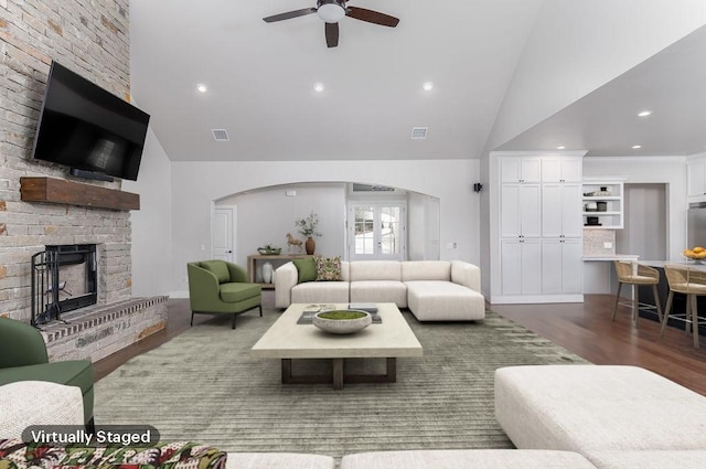 living room featuring a fireplace, dark hardwood / wood-style flooring, high vaulted ceiling, and ceiling fan