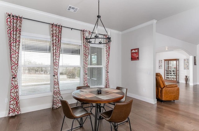 dining room featuring hardwood / wood-style flooring, crown molding, and an inviting chandelier