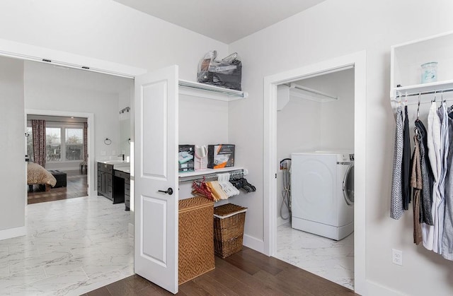 washroom with washer / clothes dryer, sink, and wood-type flooring