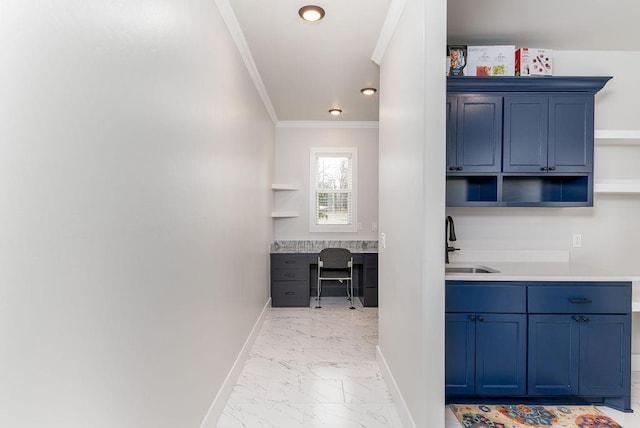 kitchen with sink, crown molding, built in desk, and blue cabinetry